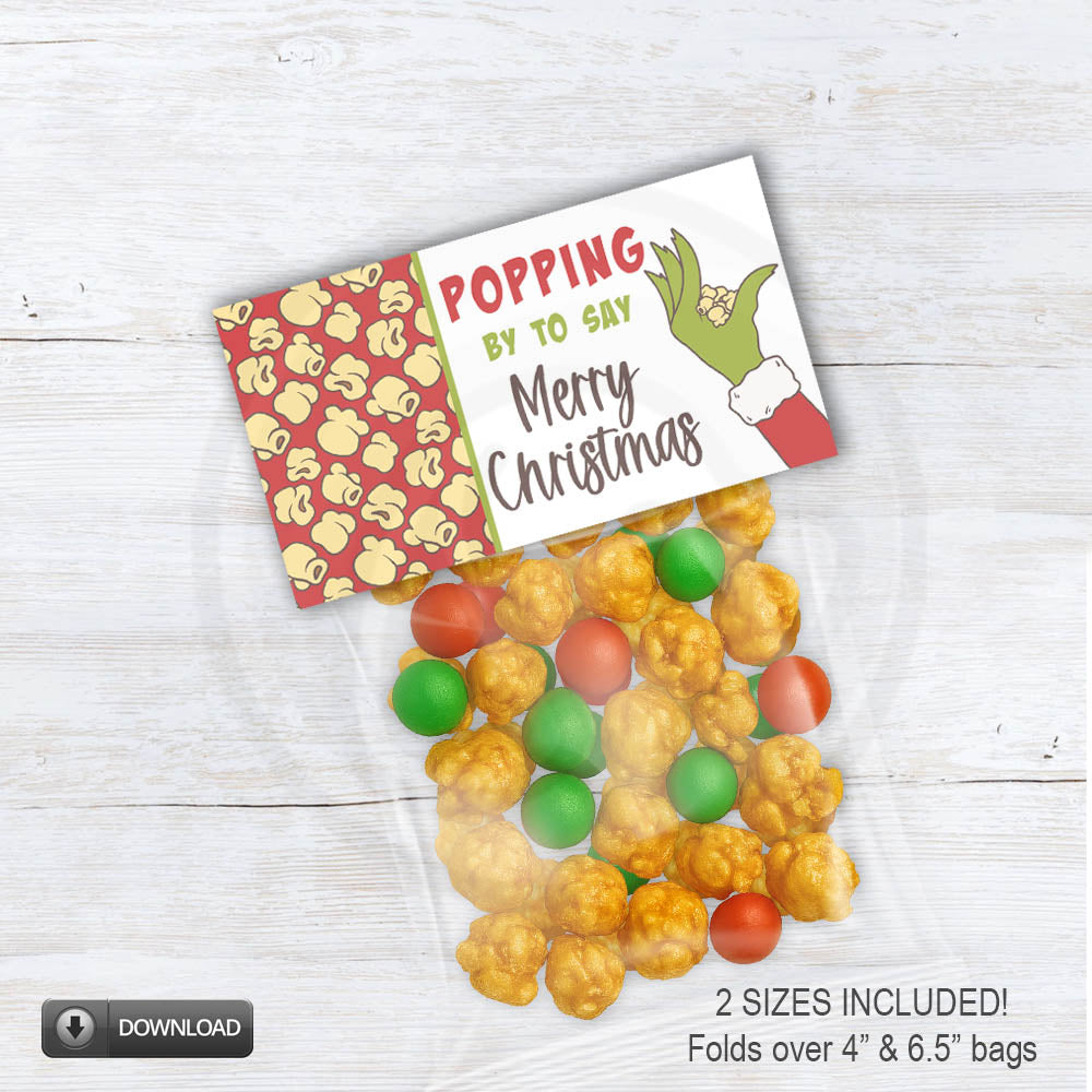 Printable Christmas popcorn bag topper with red background and green cartoon hand. Red holiday treat bag topper saying “Popping by to say Merry Christmas”