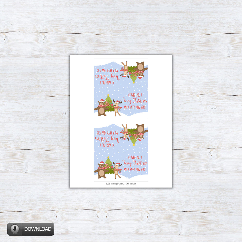 Printable Christmas treat bag topper featuring a cute reindeer and bear in scarves dancing by a Christmas tree with “We wish you a Merry Christmas and a Happy New Year” text on a snowy blue background.