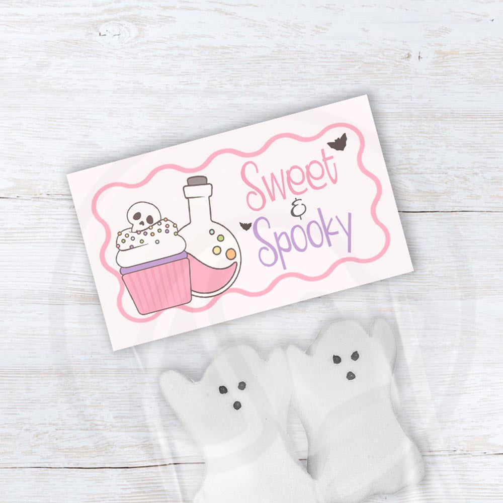 Sweet & Spooky pink Halloween treat bag topper with a skull cupcake, potion bottle, lavender lettering and a wavy pink border.