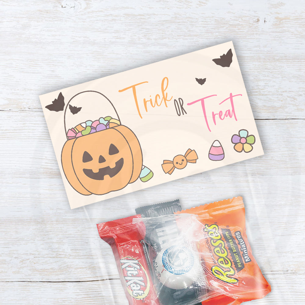 Pastel Halloween treat bag toppers with a smiling pumpkin candy basket, flying bats, colorful candy, flowers, and Trick or Treat lettering.