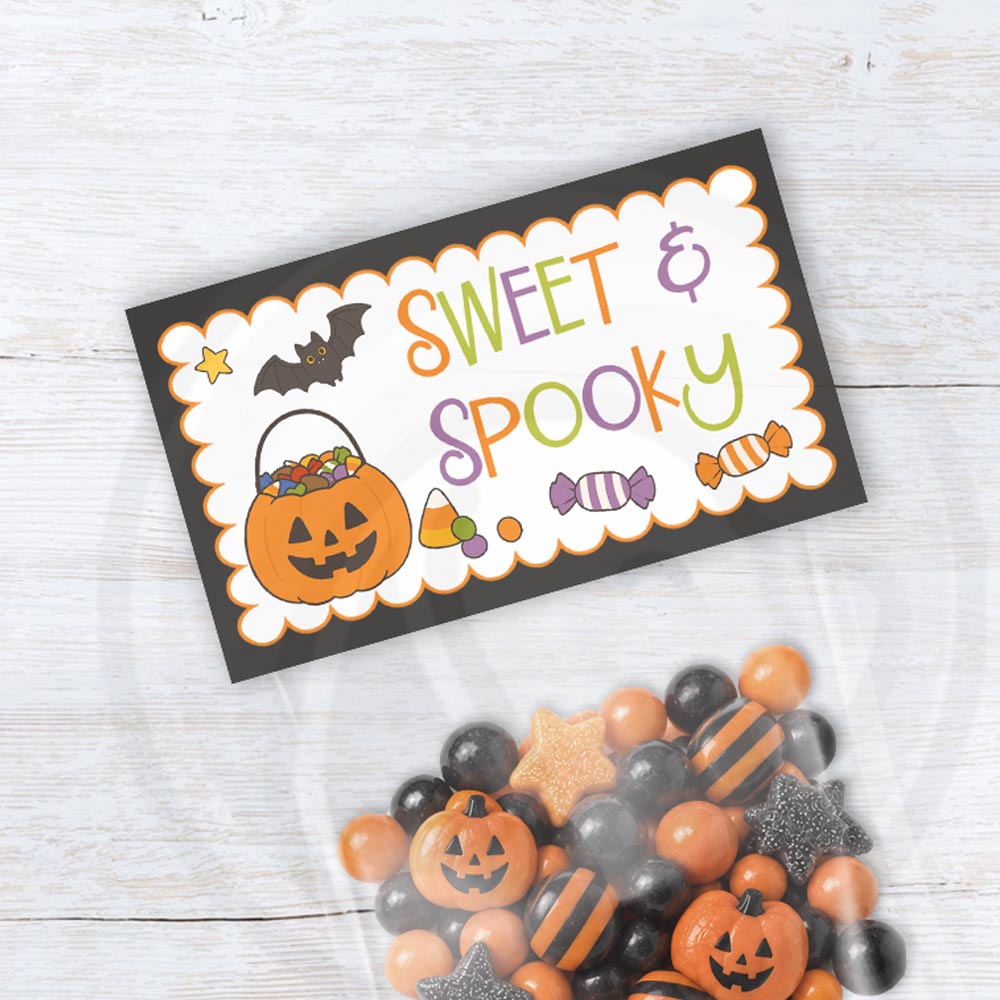 Sweet & Spooky printable Halloween bag topper with a jack-o’-lantern candy bucket, a bat, candy illustrations, colorful lettering, and a black border.