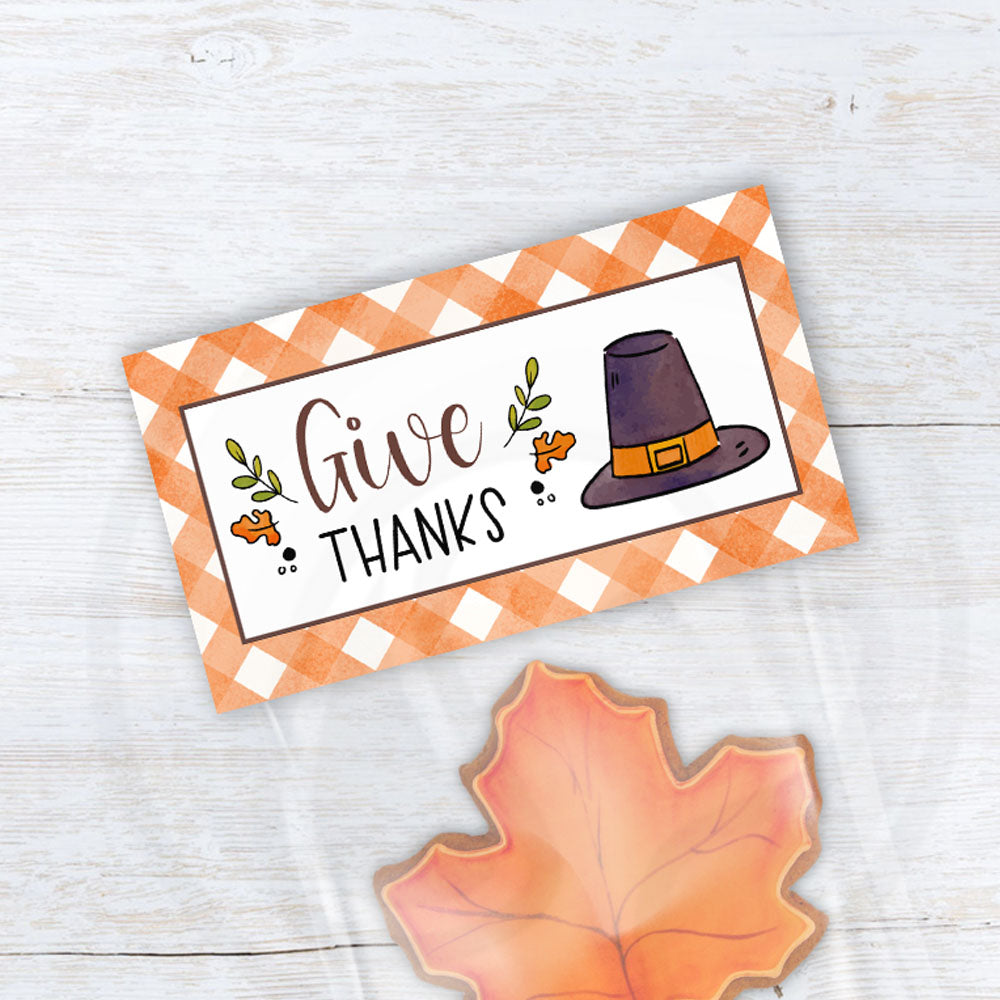 printable thanksgiving treat bag toppers with orange gingham background and the words give thanks on the front with a pilgrims hat